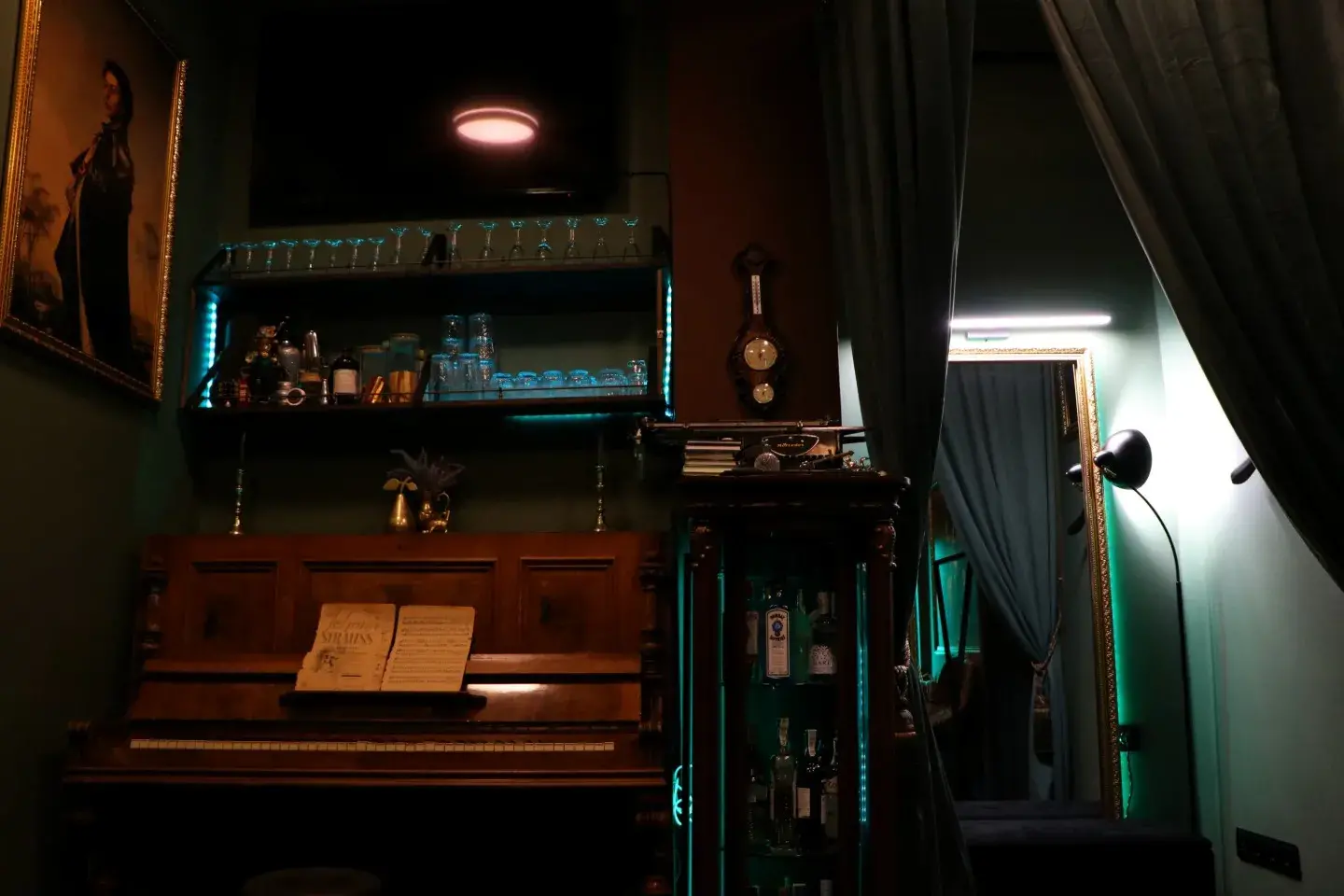 Інтер'єр 221B Store — рояль, барна полиця з келихами та зелена підсвітка